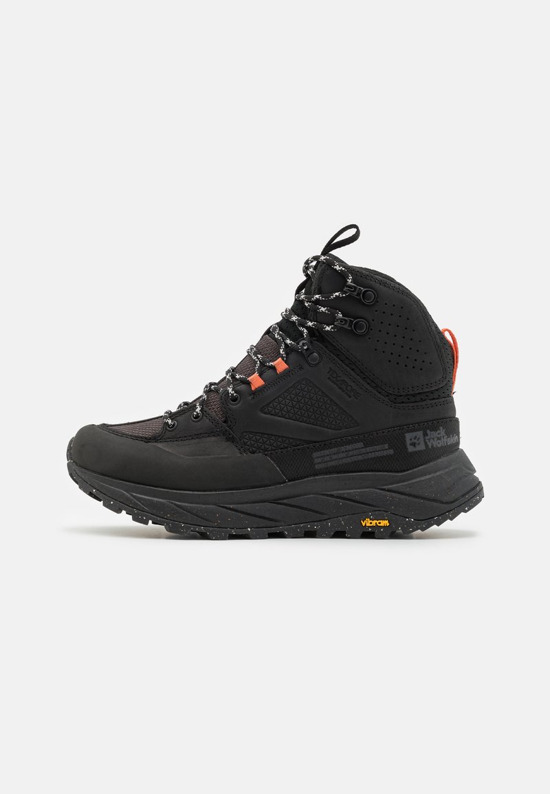 Stivale da trekking alto nero con suola robusta, lacci riflettenti, linguette arancioni e suola Vibram con marchio, mostrato su sfondo bianco.