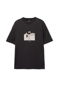Schwarz oversized T-Shirt mit einem grafischen Patch in beigem und weißem abstraktem Design. Rundhalsausschnitt und kurze Ärmel, aus Baumwollmaterial.