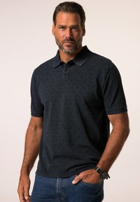 Námořnická polo košile s krátkými rukávy, strukturovaná jemným tečkovaným vzorem, obsahuje knoflíkovou légou a límec. Nosit s modrými džíny.