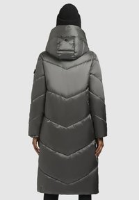 Grå pufferjacka med huva, med ett chevronmönster och lång ärm. Slät, blanka material med en design som når till mitten av låret.