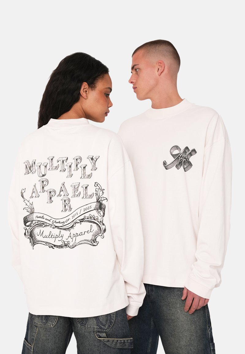Long-sleeve white shirt featuring black graphic text on the back and a smaller logo on the front. The shirt has a relaxed fit and high neckline.