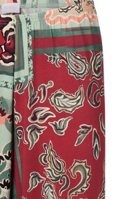 Shorts en tissu à motifs avec un fond rouge et des motifs paisley verts et rose clair, taille élastique et texture douce.