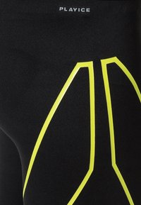 Schwarze Sportleggings mit gelben reflektierenden Akzenten in einem geometrischen Muster. Logo "PLAYICE" in Grau nahe dem Bund aufgedruckt.