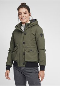 Olive green padded jacket with a hood, featuring black buttons, two front pockets, and ribbed cuffs. Textured fabric with a smooth finish.
