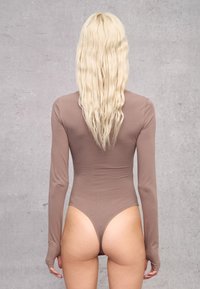 Body a maniche lunghe in marrone chiaro, design aderente, tessuto morbido, aperture per le gambe alte, copertura minima sul retro, con maniche lunghe.