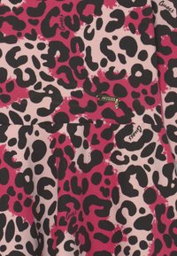 Tessuto a stampa leopardo in tonalità di rosa e nero, con un piccolo logo in metallo dorato accentuato da un dettaglio in gemma. Texture liscia.
