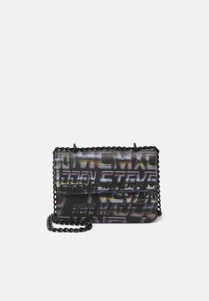 Petit sac bandoulière noir avec motif de texte irisé "Steve Madden" et anse chaîne noire sur fond uni.