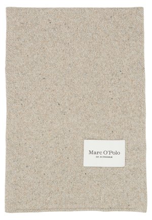 Beigen värinen neulottu kangasneliö, jonka alareunassa on ommeltu valkoinen etiketti, jossa lukee "Marc O’Polo EST. IN STOCKHOLM".