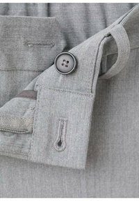 Gray fabric detail featuring a button closure, contrasting stitching, and a loop for hanging. Smooth texture with a subtle weave pattern.