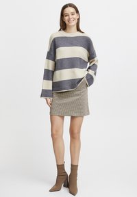 Striped knit sweater in cream and dark gray, paired with a brown houndstooth mini skirt and brown ankle booties with a square heel.