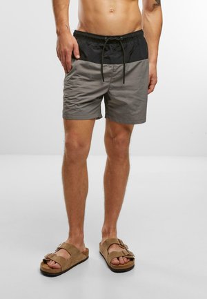 Graue und schwarze Schwimmshorts mit elastischem Bund und Kordelzug, mit glatter Oberfläche und knielangem Design.