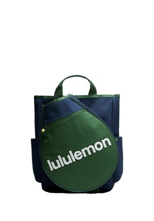 Bolsa tote bicolor azul y verde con un gran bolsillo delantero verde con forma de funda para raqueta de tenis, con texto blanco "lululemon".