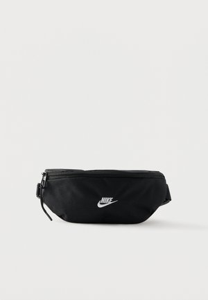 Riñonera negra de Nike con cremallera, correa ajustable y logo blanco de swoosh centrado en el frente.