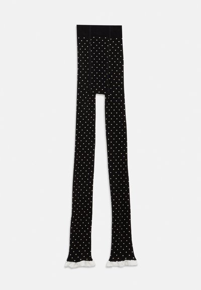 Μαύρες καλσόν με μικρές λευκές πουά και λευκό φάσκο στο τελείωμα του ποδιού, τοποθετημένες επίπεδα σε λευκό φόντο.