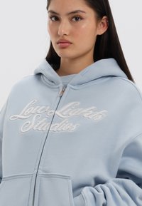 LOW LIGHTS STUDIOS® SHUTTER ZIPPER HOODIE - Camisola com fecho - sky blue