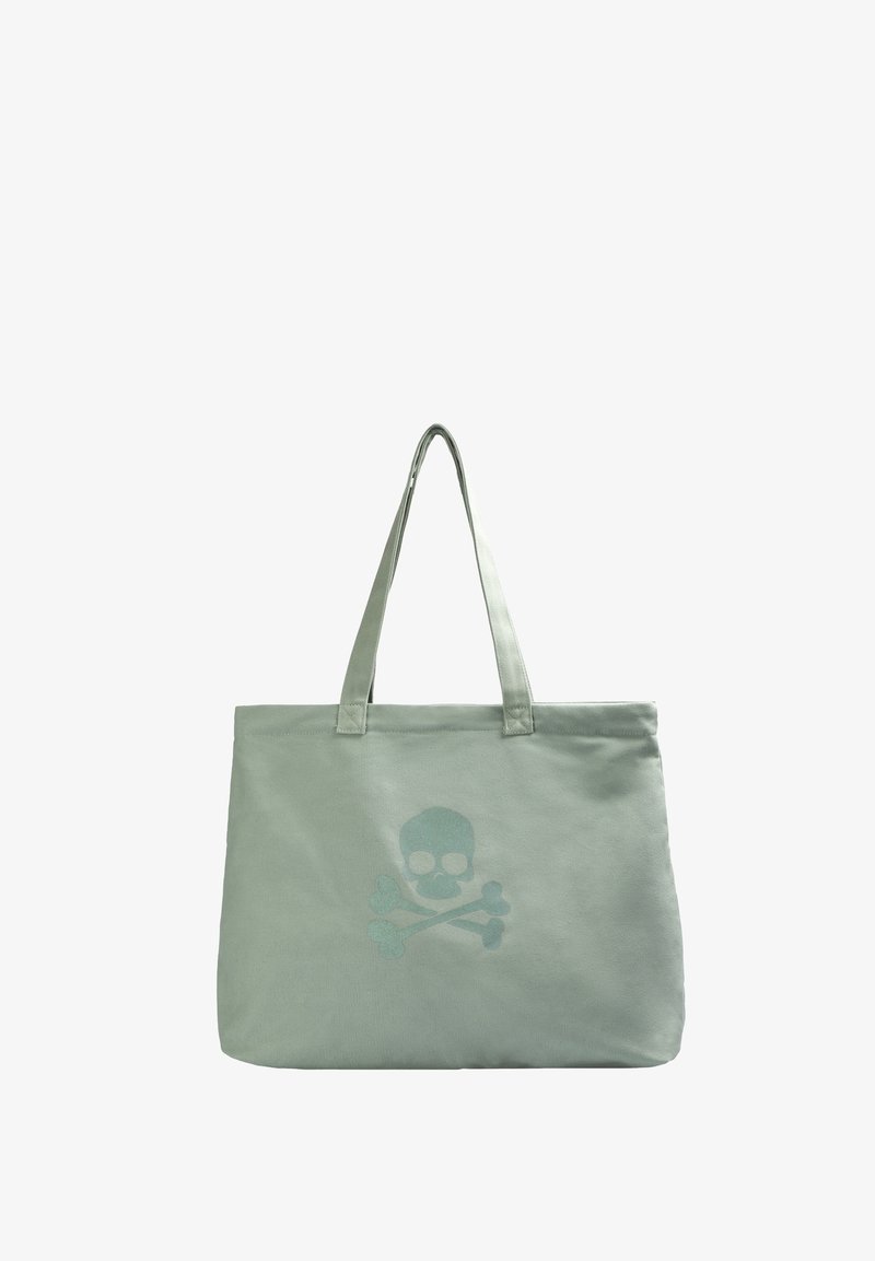 Canvas tote bag i ljusgrön, prydd med ett dödskalle- och korsbensmotiv i en ljusare nyans. Två robusta handtag för enkel bärande.