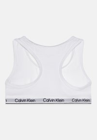 Bela sportska grudnjak od pamuka s dizajnom racerback. Sadrži elastičnu traku u crnoj i sivoj boji s logotipom "Calvin Klein". Glatka tekstura.