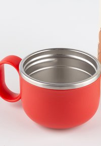 Red insulated mug with a matte finish, stainless steel interior, rounded shape, and a large handle for easy grip.