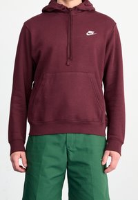 Bordó mikina s kapucí z měkké látky, s přední klokánkovou kapsou, stahovací kapucí a bílým logem Nike na hrudi.