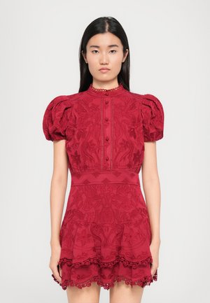 Vestido rojo bordado con mangas abullonadas, cuello alto y cierre de botones. Presenta intrincados patrones florales y un dobladillo de encaje en capas.