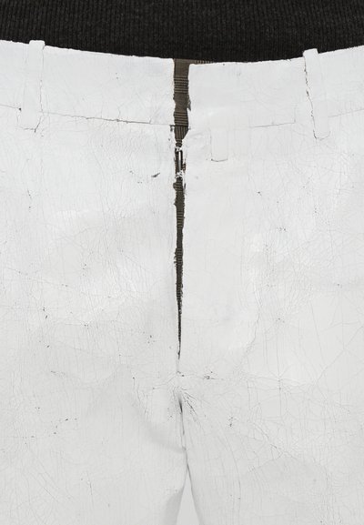 White cracked leather pants with a black zipper; features a textured surface and stitched waistband with loops for belt placement.