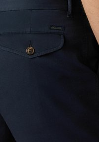 Námořnické modré bavlněné kraťasy se zadní kapsou, opatřenou zakulaceným klopou a zapínáním na knoflík, s malým logem značky našitým na pase.