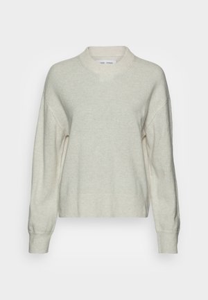 Pull oversize beige clair en tissu doux, doté d'un col rond, d'un ourlet côtelé et de manches longues tombantes pour une coupe décontractée.
