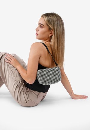 Bolso de mano con lentejuelas negras y plateadas, de forma rectangular, con una sola correa para el hombro y una superficie texturizada.