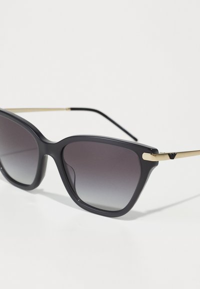 Ochelari de soare dreptunghiulari negri, cu lentile gri cu degradé, accente aurii pe brațe și o finisare mată. Design cu ramă geometrică largă.