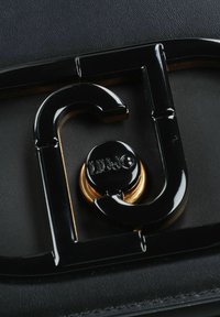 Borsa a mano in pelle nera con chiusura in metallo nero lucido con dettagli dorati e un logo, che mette in risalto un design strutturato.