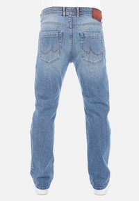 Jeans de mezclilla azul claro con un corte recto, con costuras reforzadas, dos bolsillos traseros y una etiqueta de cuero marrón con el logo en la cintura.