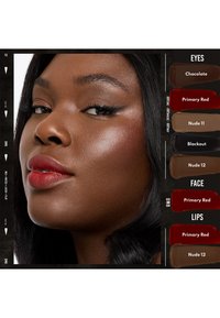 Makeup display med en modell med mørk hud, som viser frem røde lepper og subtil øyemakeup. Fargeprøver ved siden av: Sjokolade, Primær Rød, Nude 11, Blackout, Nude 12.