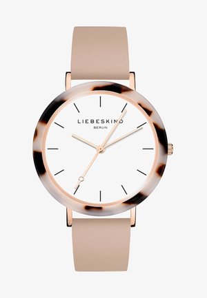 Montre-bracelet ronde avec bracelet en cuir beige, cadran blanc, marqueurs d'heure noirs minimalistes, lunette en écaille de tortue et aiguilles de couleur or indiquant 1:37:35.