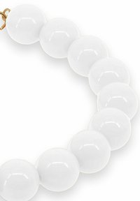 Glansede hvide runde perler strenget sammen i et armbånd med en guld spænde på en hvid baggrund.