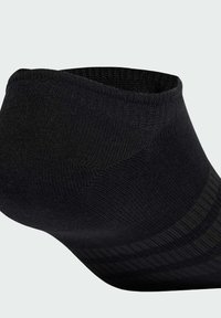 Calcetín negro de tobillo con textura acanalada, que presenta un puño ajustado y sutiles rayas horizontales para mayor agarre y estilo.