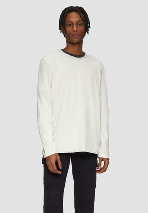 Witte lange mouwen shirt van katoen, met een ronde halslijn en een relaxte pasvorm, gecombineerd met donkere cargobroek.
