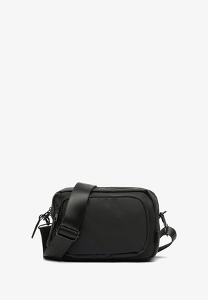 Schwarze Nylontasche für den Crossbody-Tragekomfort mit Reißverschluss, verstellbarem Tragegurt, rechteckiger Form und glatter Textur. Besitzt ein minimalistisches Design und keine sichtbaren Logos.