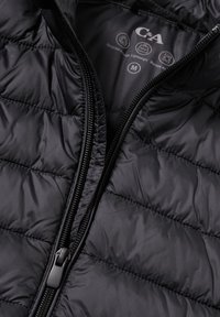 Czarna pikowana kurtka o błyszczącej, lekkiej teksturze. Posiada przedni zamek błyskawiczny oraz widoczny pikowany wzór. Wykonana z materiałów pochodzących z recyklingu.