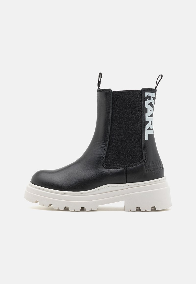 Sorte skinn Chelsea-boots med elastiske sidepaneler og hvit chunky såle. Har preget logo og løpebånd for enkel påkledning.