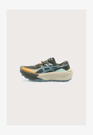 Chaussure de course à profil bas en vert avec des accents bleus et orange, semelle beige épaisse et coussinée, et fermeture à lacets vue de côté.
