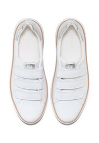Sneaker bianchi in pelle con tre cinturini in Velcro, punta rotonda, dettagli argento e suola in gomma beige. Design minimalista con texture liscia.