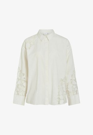 Camicia bianca con bottoni, caratterizzata da maniche lunghe con ricami floreali sulle spalle e sulle maniche, realizzata in tessuto leggero.