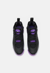 Svarta atletiska sneakers med lila detaljer, texturerad läderöverdel, rund tå och snörningssystem; Jordan-logotyp synlig på tungan.