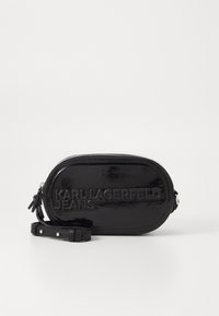 Borsa ovale in vernice nera con logo in rilievo "KARL LAGERFELD JEANS", chiusura con zip e tracolla removibile. Presenta una texture liscia.