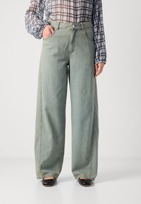Lyseblå vide jeans laget av denim, med høyt liv, frontlommer og synlige sømmer langs sidesømmene.