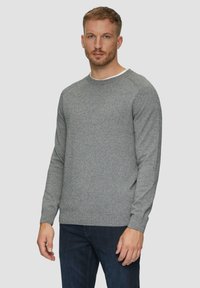 Szary sweter wykonany na drutach z okrągłym dekoltem i długimi rękawami. Teksturowana tkanina oraz gładki, biały wewnętrzny kołnierz. Dobierany do ciemnoniebieskich dżinsów.