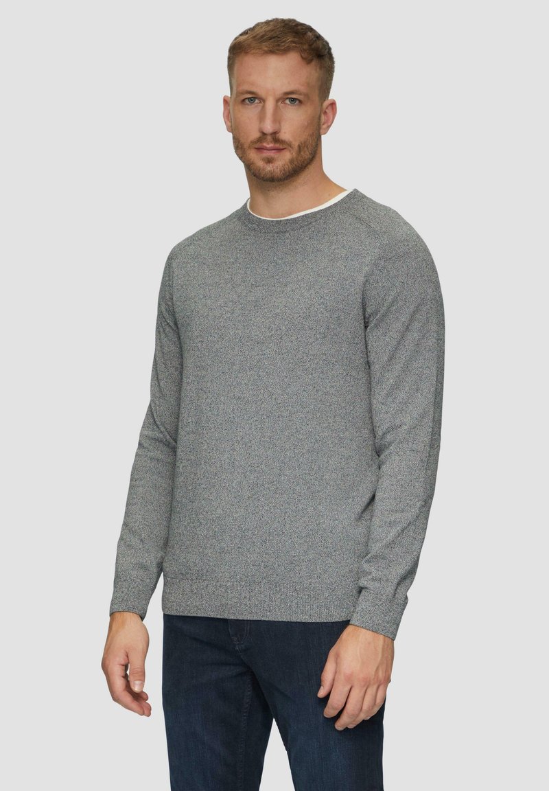 Szary sweter wykonany na drutach z okrągłym dekoltem i długimi rękawami. Teksturowana tkanina oraz gładki, biały wewnętrzny kołnierz. Dobierany do ciemnoniebieskich dżinsów.