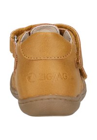Braune Leder-Sandale für Kinder mit verstellbarem Riemen, Gummisohle und geprägtem Logo-Detail. Abgerundete Ferse und strukturierte Oberfläche.