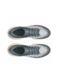 Baskets de sport grises avec une tige tricotée texturée, des lacets ton sur ton et une semelle beige. Design épuré avec des motifs subtils.