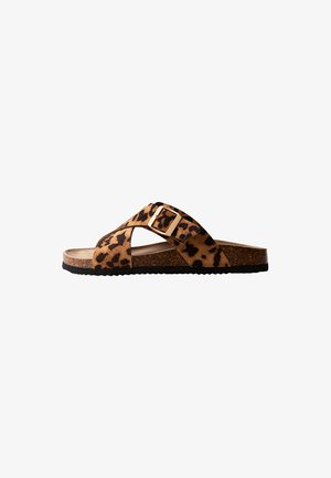 Leopard print slide sandal with a cross strap design, cork footbed, and a gold buckle accent. Rubber outsole for grip and stability.